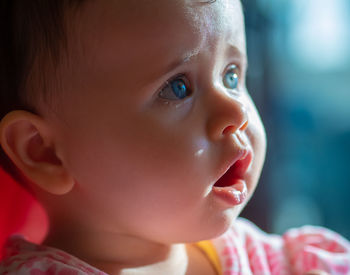 Baby with blue eyes looking to the side.