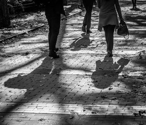 Low section of woman standing on footpath