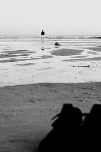 Silhouette people on beach against sky