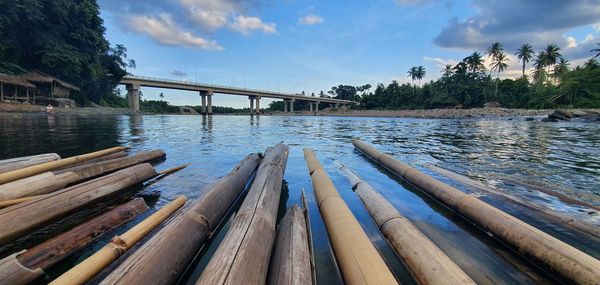 Wooden bridge over river against sky