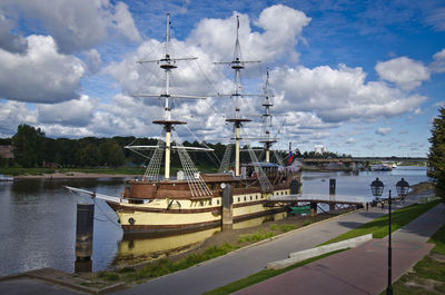 Sailboats moored on river against sky