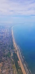 Aerial view of city by sea against sky