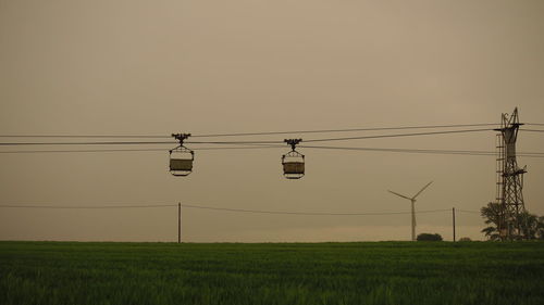 Electricity pylon on field against sky during sunset