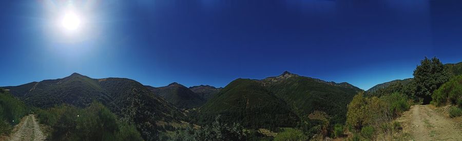 Panoramic view of mountains against clear blue sky