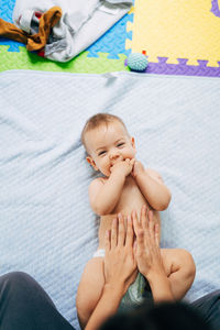 High angle view of baby girl lying on bed