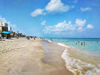 People at beach against sky