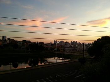 Railroad tracks against sky at sunset