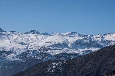 Scenic view of snowcapped mountains against clear blue sky