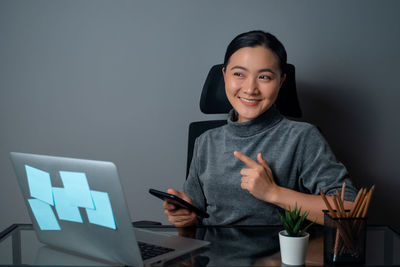 Portrait of smiling young woman using smart phone