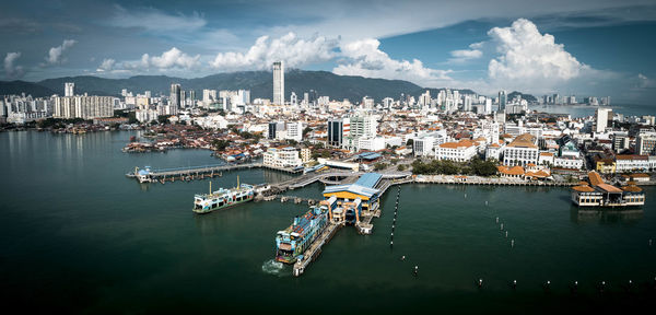 High angle view of sailboats in city by sea against sky