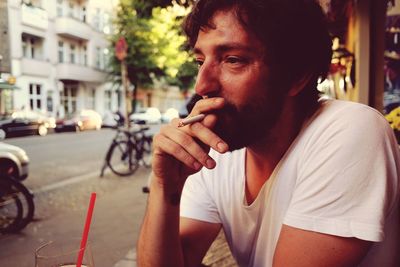 Man smoking cigarette at sidewalk cafe