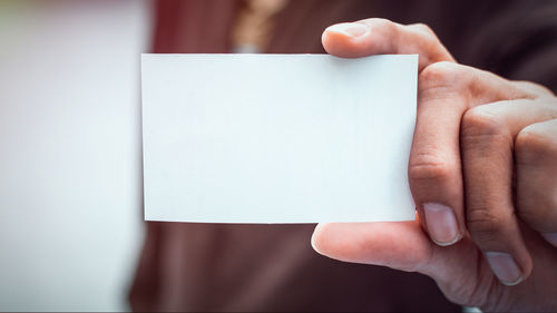 Midsection of person holding paper with text