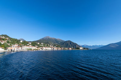 Scenic view of sea and mountains against clear blue sky