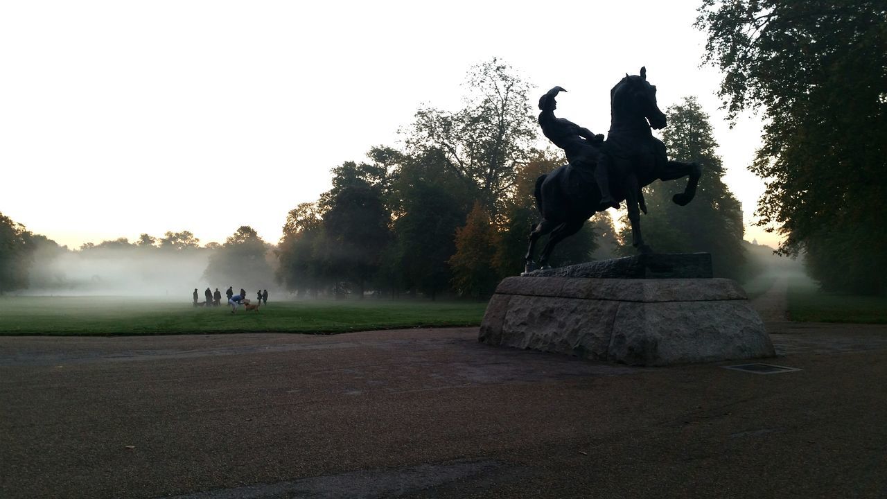 clear sky, tree, statue, human representation, art and craft, sculpture, art, creativity, silhouette, sunlight, tranquility, landscape, field, nature, sunset, no people, outdoors, sky, copy space