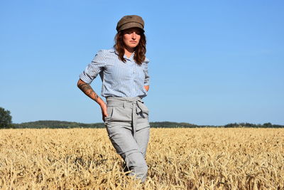 Thoughtful woman standing on wheat field during sunny day