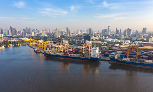 Scenic view of river by buildings against sky in city