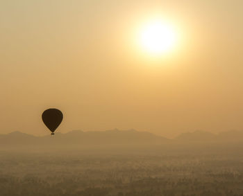 Silhouette hot air balloon against sky during sunset