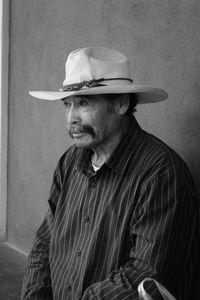 Portrait of man wearing hat against wall