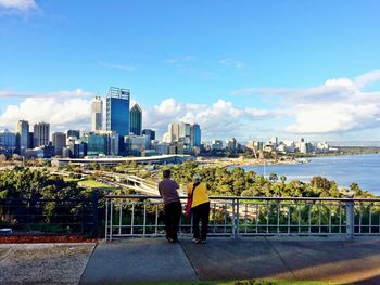 Rear view of people looking at cityscape