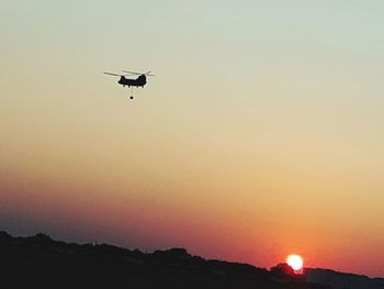 Low angle view of silhouette bird flying against sky during sunset