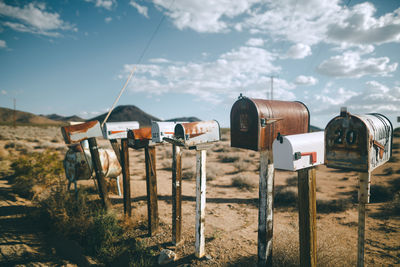 Wooden posts on field against sky