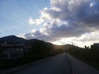 Road amidst buildings against sky