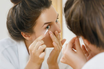 Woman removing mucus from eyes