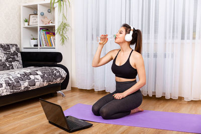 Woman drinking water at home