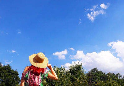Low angle view of woman standing against sky