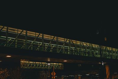 Illuminated bridge against sky at night