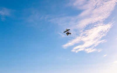 Low angle view of airplane flying against sky