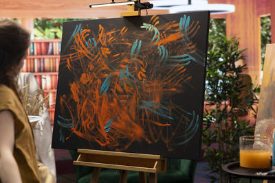 Rear view of woman sitting on table