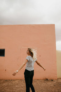 Full length of woman standing against wall