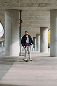 Young man skateboarding on footpath