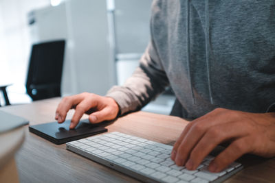 Midsection of man using laptop on table