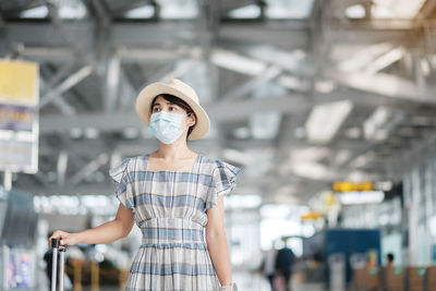 Woman wearing flu mask standing at airport