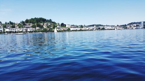 Scenic view of sea by buildings against sky