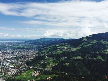 Aerial view of city by sea against sky