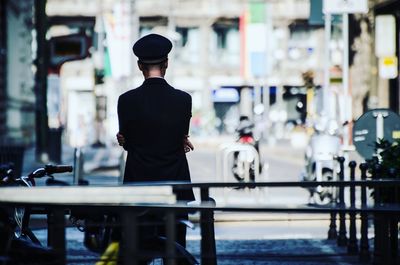 Rear view of police standing on road in city