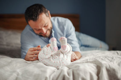 Midsection of man lying on bed at home