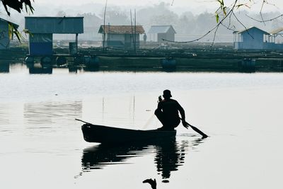Rear view of man on boat in canal