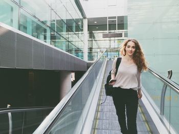 Portrait of beautiful woman on escalator in airport