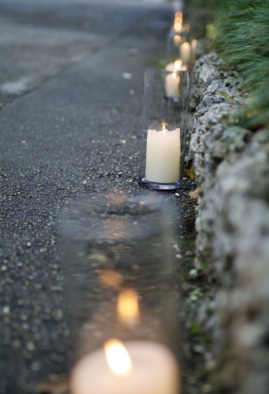 CLOSE-UP OF LIT CANDLE ON WATER