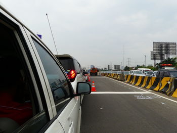 Cars on road in city against sky