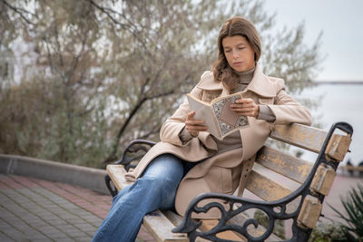 Portrait of young woman sitting on bench