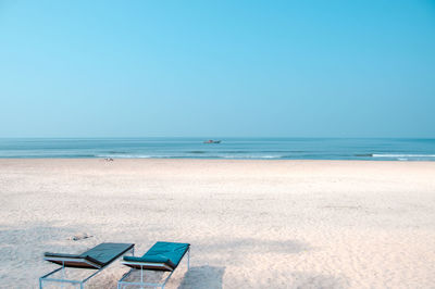 Two beach chairs on a secluded beach, clean modern composition