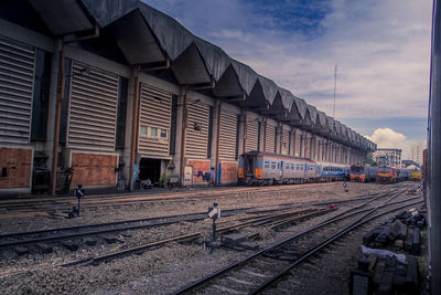 Train at railroad yard against sky. 