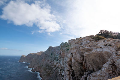 Rock formations by sea against sky