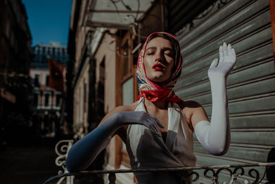 Portrait of woman standing against building