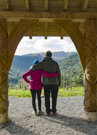 Rear view of couple embracing each other against mountains